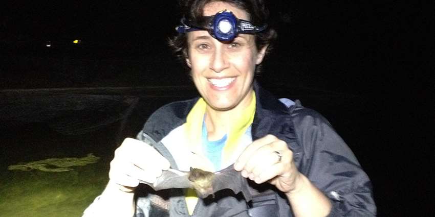 Dr. Jessica Light, holding a bat in the evening